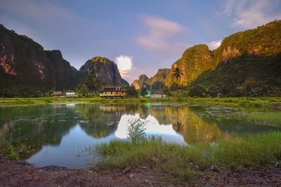 Scenic view of lake by mountains against sky