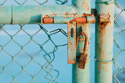 Close-up of rusty padlock on gate