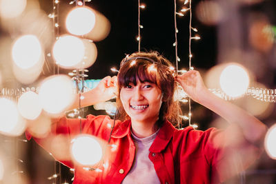 Portrait of smiling woman with illuminated lights