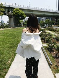 Rear view of woman with umbrella walking in park