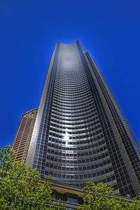 Low angle view of modern building against clear blue sky