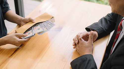 High angle view of man holding hands on table