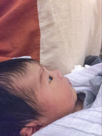 Close-up of baby lying on bed