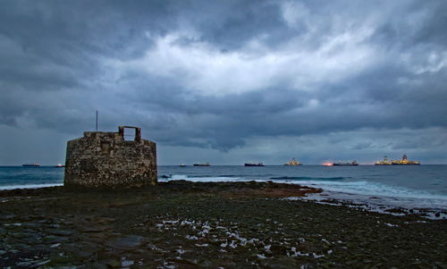 Built structure on beach against sky