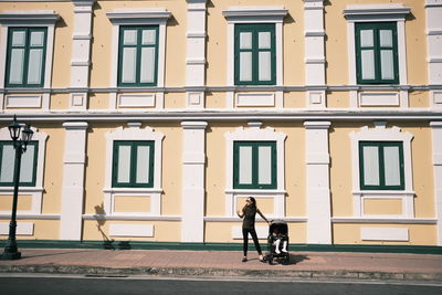 Full length of man walking on street against building in city