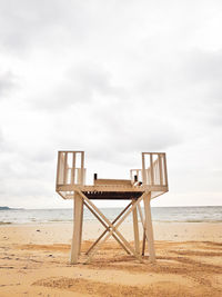 Lifeguard hut on beach against sky