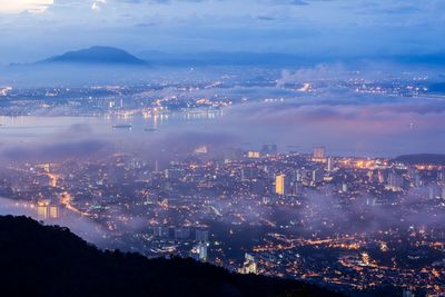 Aerial view of illuminated cityscape against sky at night