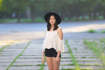 Young woman standing against lake