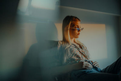 Portrait of a young woman wearing sunglasses during sunset