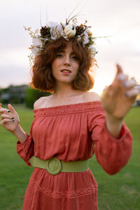 Beautiful woman standing by flower on field
