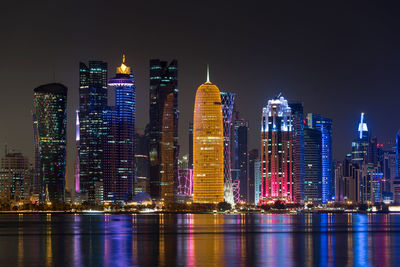 Illuminated buildings against sky at night