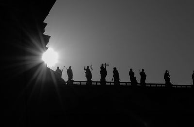 Silhouette people against clear sky during sunset