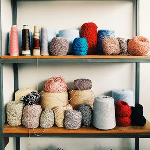 Multi colored wool on shelves against wall