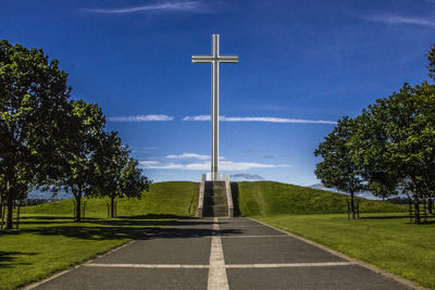 Large cross on landscape against blue sky