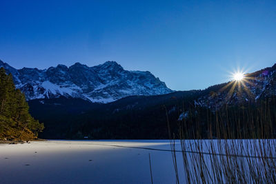 Scenic view of snowcapped mountains against clear blue sky