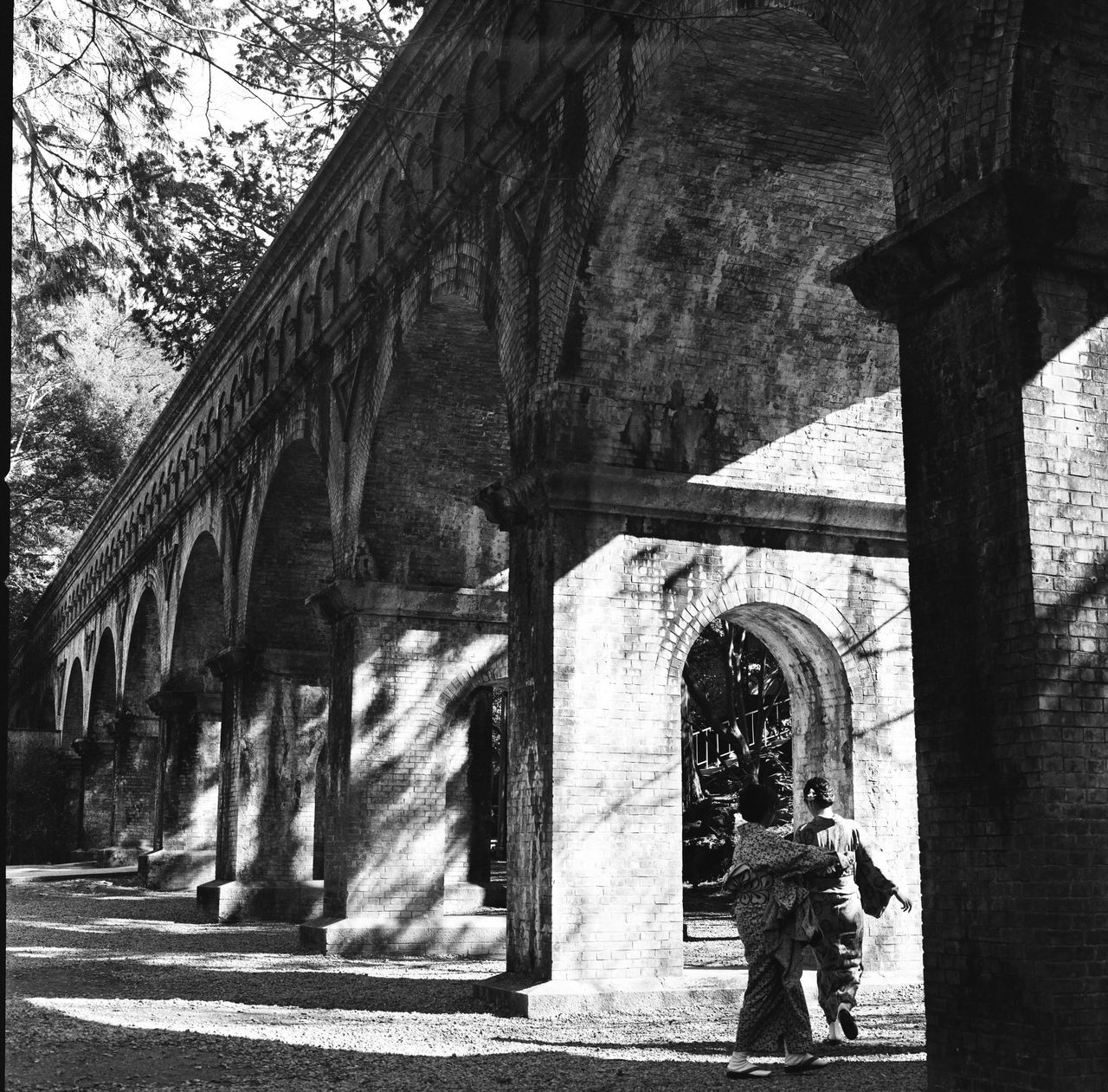 MAN STANDING ON BRIDGE IN PARK