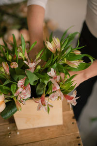 Midsection of woman holding bouquet of flowering plant