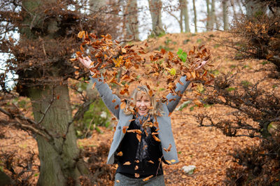 Rear view of woman standing against trees