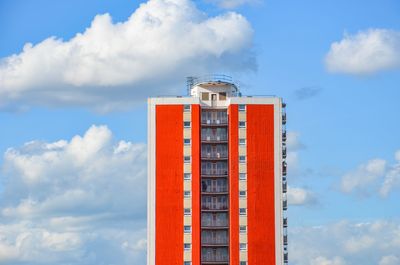 Red skyscraper against blue sky