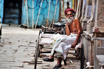 Portrait of man sitting on street