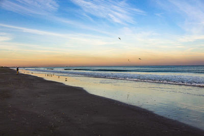 Scenic view of beach against sky during sunset