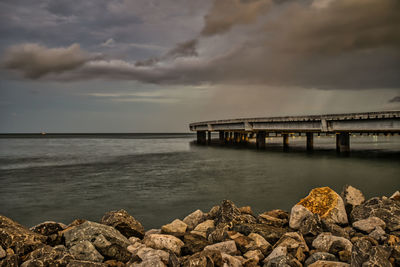 Bridge over sea against sky during sunset