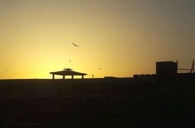 Silhouette of building against sky during sunset