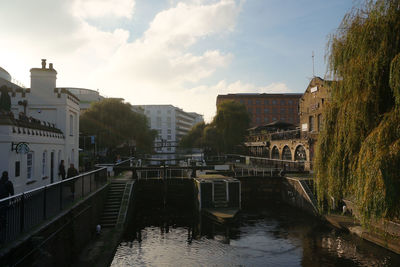 Bridge over river in city against sky