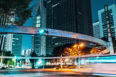 Light trails on city street by buildings at night