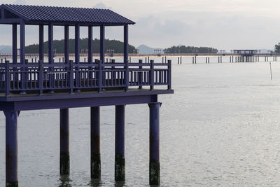 Built structure on pier by sea against sky