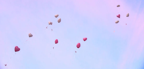 Low angle view of balloons flying against sky
