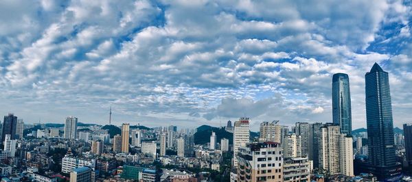 Aerial view of buildings in city against sky