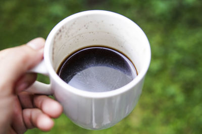 Close-up of hand holding coffee cup outdoors