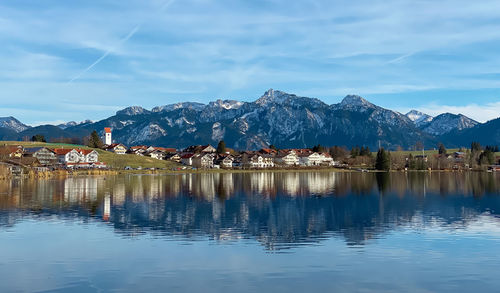 Scenic view of lake by snowcapped mountains against sky