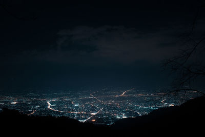 Illuminated cityscape against sky at night