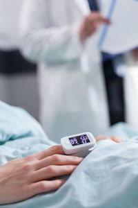 Midsection of man using mobile phone on bed