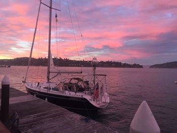 Boats in sea against cloudy sky