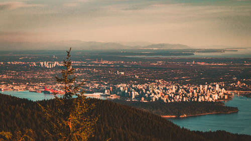 Panoramic view of city and sea against sky during sunset