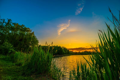 Scenic view of river against sky at sunset