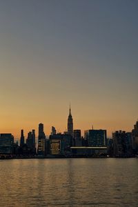 View of buildings at waterfront during sunset
