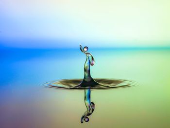 Close-up of water drop on sea against sky