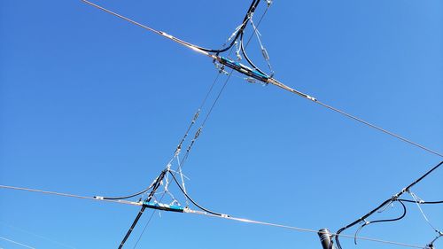 Low angle view of power lines against clear blue sky