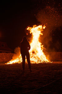 Rear view of young woman looking at bonfire