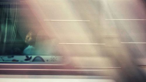 Blurred motion of car on street seen through glass window