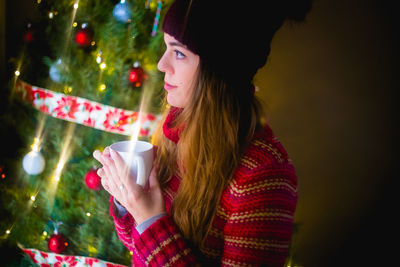 Midsection of a woman drinking water from christmas tree