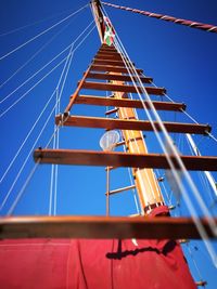 Low angle view of metallic building against clear blue sky