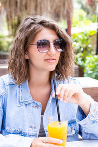 Portrait of smiling young woman having drink in cafe