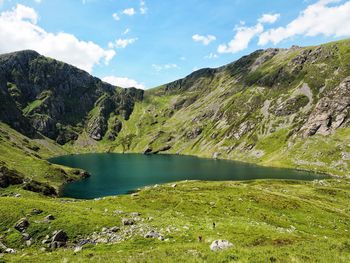 Scenic view of lake by mountain against sky