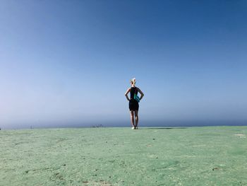 Full length of woman standing on land against clear sky