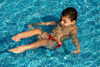 High angle view of boy swimming in pool